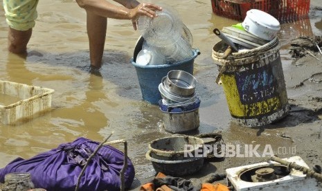   Warga membersihkan barang-barang pasca banjir bandang di Tarogong Kidul, Kabupaten Garut, Kamis (22/9). 