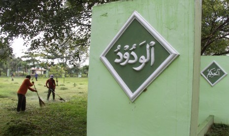 Warga membersihkan lokasi kuburan massal korban bencana tsunami di Desa Ulee Lheue, Banda Aceh, Senin (19/12). 