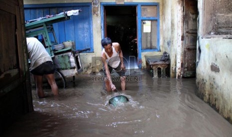   Warga membersihkan lumpur saat banjir yang menggenangi Kampung Pulo, Kampung Melayu, Jakarta Timur, Jumat (12/7).    (Republika/ Yasin Habibi)