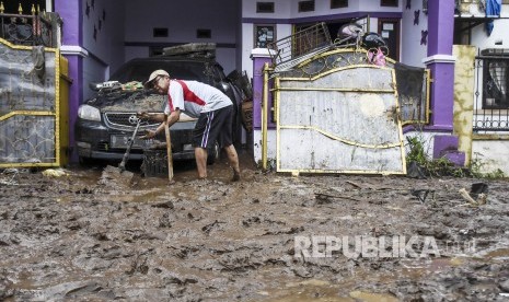 Warga membersihkan lumpur sisa banjir di Komplek Perumahan Cimareme Indah, Desa Cimareme, Kecamatan Ngamprah, Kabupaten Bandung Barat, Rabu (1/1). 