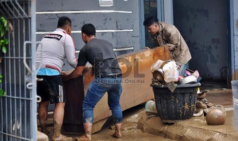 Warga membersihkan lupur sisa banjir di Perumahan Pondok Gede Permai, Bekasi, Ahad (23/2).