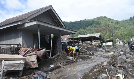 Warga membersihkan material vulkanis erupsi Gunung Semeru di rumahnya di Dusun Kamarkajang, Desa Sumberwuluh, Candipuro, Lumajang, Jawa Timur, Senin (10/1/2022). Sejumlah alat berat dan warga dusun tersebut terus membersihkan jalur lalu lintas dan rumahnya karena material vulkanis erupsi Gunung Semeru masih tetap turun melalui daerah aliran sungai setempat.