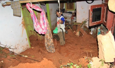 Warga membersihkan meterial tanah longsor yang menghantam rumahnya di Desa Kalijati, Kabupaten Pangandaran, Jawa Barat, Sabtu (7/10). Akibat hujan deras yang mengguyur Kabupaten Pangandaran mengakibatkan empat orang tewas tertimbun tanah longsor. 