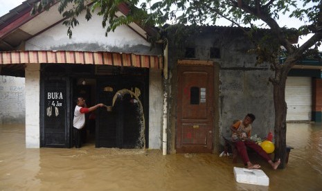 Warga membersihkan rumahnya yang terendam banjir di kawasan Perumahan Pondok Gede Permai, Jatiasih, Bekasi, Jawa Barat, Jumat (22/4). (Antara/Akbar Nugroho Gumay)