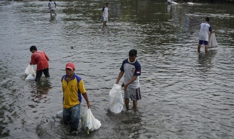 Warga membersihkan sampah di sungai Code, Mergangsan, DI Yogyakarta, Minggu (19/3). 