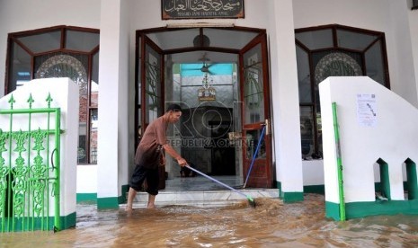  Warga membersihkan teras masjid saat banjir di Jalan Kampung Melayu Kecil,Jakarta Timur, Selasa ( 5/3).  (Republika/Prayogi)