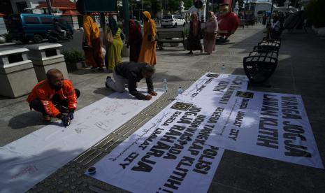 Warga membubuhkan tanda tangan di kain saat pernyataan sikap Aksi Warga Jogja Lawan Klitih di kawasan Titik Nol KM, Yogyakarta, Senin (3/1/2022). Aksi yang digagas oleh Garda Umat DIY itu mendesak aparat penegak hukum agar menindak tegas para pelaku klitih atau kejahatan jalanan.