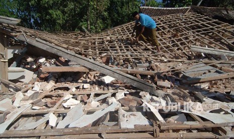 Warga memeriksa bagunan Madrasah yang ambruk akibat gempa di Desa Bula'an, Sumenep, Jawa Timur, Kamis (14/6). 