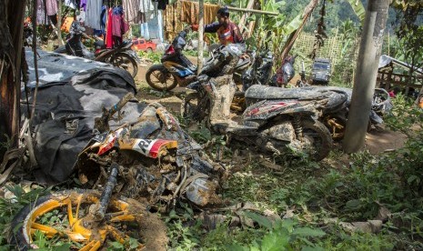 Warga memeriksa kendaraannya yang ditemukan oleh petugas SAR gabungan pascabencana tanah longsor di Desa Sirnaresmi, Cisolok, Kabupaten Sukabumi, Jawa Barat, Jumat (04/01).