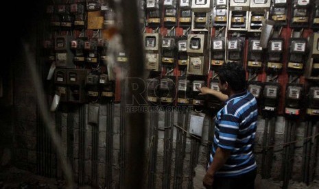 Warga memeriksa meteran listrik, di Rumah Susun Tanah Tinggi, Jakarta, Senin (30/6).