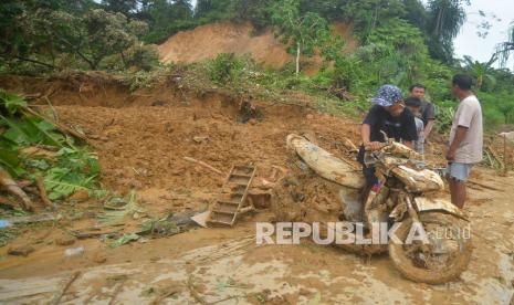 Warga memeriksa motornya yang rusak akibat longsor di Korong Tanah Taban, Nagari Pasie Laweh, Lubuk Alung, Kabupaten Padangpariaman, Sumatera Barat, Kamis (30/9/2021). Data BPBD Padangpariaman, longsor yang terjadi pada Rabu (29/9/2021) malam itu mengakibatkan satu unit rumah rusak berat, satu bangunan gudang tertimbun longsor dan tujuh orang warga meninggal dunia, satu warga luka berat. 