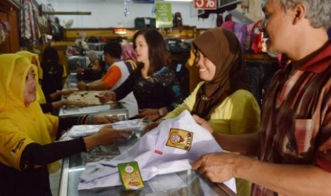 Warga memilih pakaian seragam sekolah untuk anak mereka di sebuah toko peralatan sekolah, Ahad (26/7)