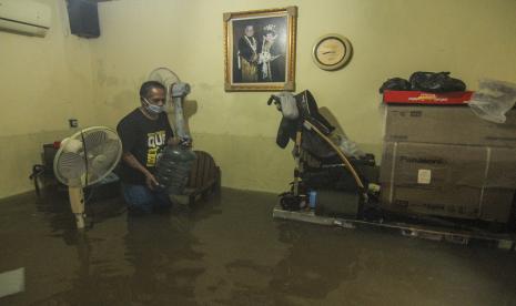 Warga memindahkan barang yang terendam banjir di Cimanggis, Depok, Jawa Barat, Sabtu (20/2/2021). Banjir di kawasan tersebut disebabkan meluapnya aliran Kali Cipinang Timur akibat intensitas hujan yang tinggi.