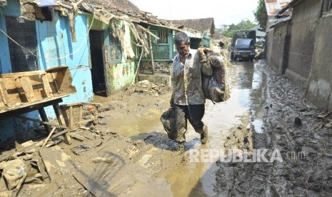 Warga memindahkan sisa-sisa barang pasca banjir bandang di Kampung Cimacan, Kecamatan Tarogong Kidul, Kabupaten Garut, Rabu (21/9)