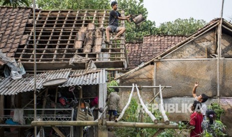 Warga memperbaiki atap rumahnya yang rusak akibat angin puting beliung di Kampung Pasirpeuti, Sukaluyu, Kabupaten Cianjur, Jawa Barat, Sabtu (12/01/2019). 