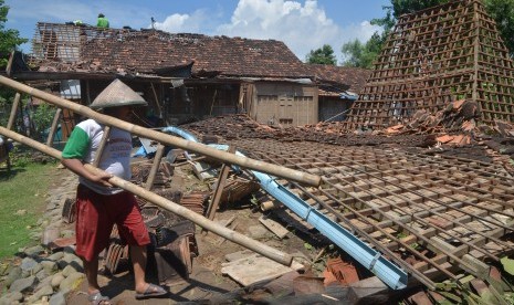 Warga memperbaiki rumah yang rusak akibat diterjang angin puting beliung di Desa Bringinwareng, Winong, Pati, Jawa Tengah, Senin (10/1). 