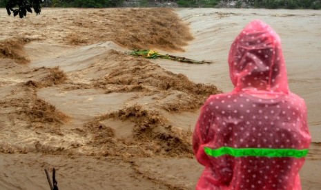 Warga memperhatikan aliran sungai Jeneberang yang meluap di Kabupaten Gowa, Sulawesi Selatan, Selasa (22/1/2019). Meluapnya sungai Jeneberang akibat curah hujan yang tinggi membuat sejumlah daerah di Kabupaten Gowa terendam banjir. 