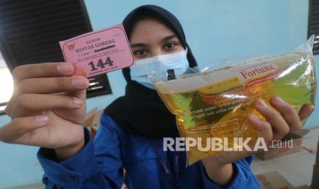 Warga memperlihatkan kupon pembelian minyak goreng berharga murah saat operasi pasar murni di Kelurahan Ngampel, Kota Kediri, Jawa Timur, Senin (11/4/2022). Ikatan Pedagang Pasar Indonesia (Ikappi) berharap persoalan minyak goreng tak jadi konflik berkepanjangan.