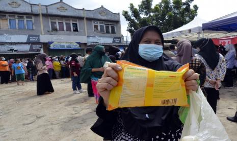 Warga memperlihatkan minyak goreng kemasan murah saat operasi pasar di Pasar Kangkung, Bandar Lampung, Lampung, Jumat (14/1/2022). Pemerintah Provinsi Lampung bekerjasama dengan distributor PT Tunas Baru Lampung menggelar operasi pasar minyak goreng kemasan murah dengan harga Rp14.000 per liter dengan total minyak goreng sebanyak 2.400 liter. 