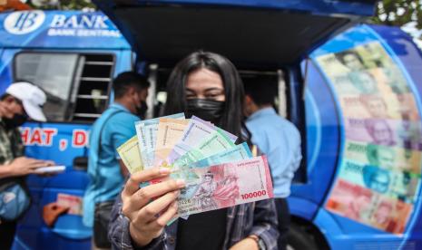 Warga memperlihatkan uang Rupiah kertas terbaru usai menukarkan di mobil kas keliling Kantor Perwakilan (KPw) Bank Indonesia Kalteng di Pasar Kahayan, Palangka Raya, Kalimantan Tengah, Senin (22/8/2022). KPw Bank Indonesia Kalimantan Tengah membuka pelayanan penukaran tujuh pecahan uang Tahun Emisi (TE) 2022 yakni Rp1.000, Rp2.000, Rp5.000, Rp10.000, Rp20.000, Rp50.000 dan Rp100.000 dengan cara berkeliling di kota itu sebagai upaya sosialisasi uang baru kepada masyarakat. 