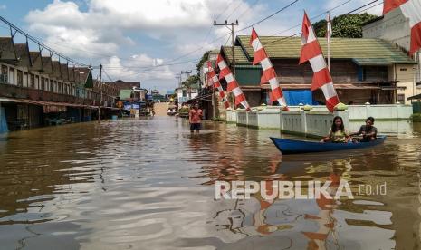 Warga menaiki perahu bermesin saat banjir terjadi di permukiman Desa Mentaya Hulu, Kotawaringin Timur, Kalimantan Tengah, Kamis (7/10/2021). Berdasarkan data Badan Penanggulangan Bencana Daerah (BPDB) setempat sebanyak enam kecamatan atau 1.256 rumah dari 35 desa di Kotawaringin Timur terdampak banjir luapan Sungai Mentaya yang disebabkan intensitas hujan tinggi dalam seminggu terakhir. 