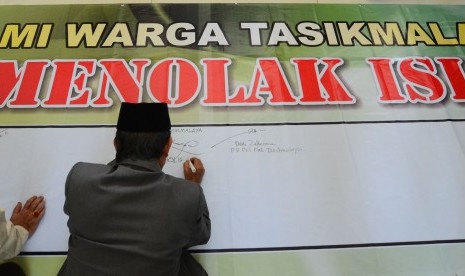 Warga menandatanagi spanduk penolakan keberadaan Negara Islam Irak dan Suriah atau disebut Islamic State of Iraq and Sham (ISIS) di Mesjid Agung Kabupaten Tasikmalaya, Singaparna, Jawa Barat, Jumat (8/8).