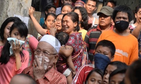 Warga menangis histeris melihat rumah tinggalnya dirobohkan oleh alat berat di permukiman padat di bantaran sungai Ciliwung di Kampung Pulo, Kampung Melayu, Jatinegara, Jakarta, Jumat (21/8). 