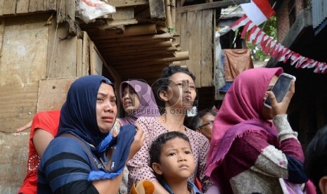 Warga menangis histeris melihat rumah tinggalnya dirobohkan oleh alat berat di permukiman padat di bantaran sungai Ciliwung di Kampung Pulo, Kampung Melayu, Jatinegara, Jakarta, Jumat (21/8). 