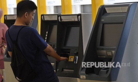 Warga menarik uang tunai dari mesin anjungan tunai mandiri (ATM) di salah satu galeri ATM di Kebayoran Lama, Jakarta.