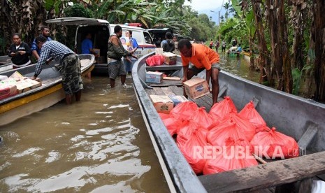 Warga menata bantuan ke dalam perahu untuk disalurkan ke tempat pengungsian di sekitar Danau Sentani di Kampung Yamin di Sentani, Jaya Pura, Papua, Rabu (20/3/2019). 