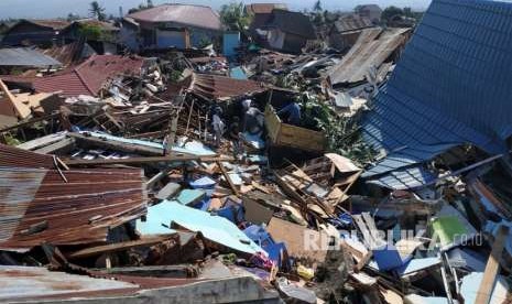 Warga mencari barang berharga di rumahnya yang hancur akibat gempa di Perumnas Bala Roa, Palu, Ahad (30/9).