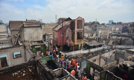 Warga mencari harta benda nya yang masih utuh dari puing rumah yang hangus terbakar di Kelurahan Kebon Melati, Tanah Abang, Jakarta Pusat, Jumat (6/3).