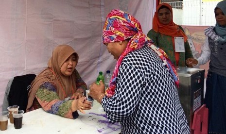 Warga mencelupkan jarinya ke dalam tinta usai melakukan pencoblosan ulang dalam pemungutan suara ulang (PSU) Pilkada DKI Jakarta Sabtu (22/4).