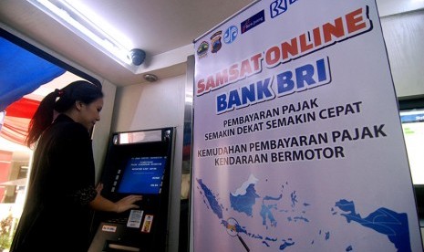 Warga mencoba pembayaran pajak kendaraan bermotor (PKB) melalui mesin anjungan tunai mandiri (ATM) BRI usai diluncurkan di Ungaran, Kabupaten Semarang, Jawa Tengah, Senin (28/12).