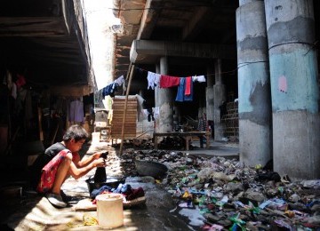 Warga mencuci pakaian di bawah kolong jembatan tol Gedong Panjang, Penjaringan, Jakarta Utara, Senin (5/3). (Republika/Aditya Pradana Putra)