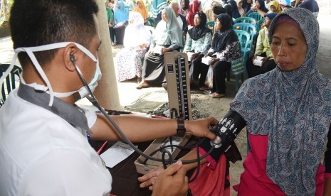 Warga mendapatkan layanan kesehatan gratis saat bakti sosial pengobatan massal gratis oleh Pemkab Madiun di Desa Kanung, Sawahan, Kabupaten Madiun, Jawa Timur, Rabu (20/2/2019).