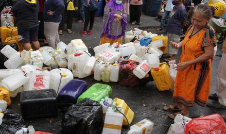 Warga menderetkan jerigen saat mengantre untuk membeli minyak goreng curah di salah satu distributor di Makassar, Sulawesi Selatan, Selasa (19/4/2022). Warga setempat lebih memilih membeli minyak goreng curah seharga Rp15.500 per kilogram meskipun harus mengantre serta menunjukkan Kartu Tanda Penduduk (KTP) daripada membeli minyak goreng kemasan yang harganya mahal. 