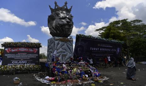 Warga mendirikan karangan bunga duka di sekitar Patung Singa Stadion Kanjuruhan, Malang, Jawa Timur, Selasa (4/10/2022). Ratusan karangan bunga duka cita berderet di area Stadion Kanjuruhan, Malang, Jatim.