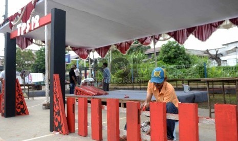 Warga mendirikan TPS 12 jelang Pilkada Serentak di Depok, Jawa Barat, Selasa (8/12).  (Republika/Wihdan)