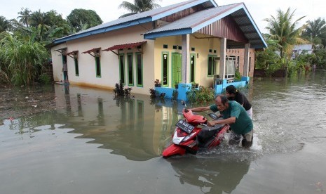 Warga mendorong sepeda motor melintasi banjir di kompleks perumahan Sawah Lebar Baru, Bengkulu, ilustrasi