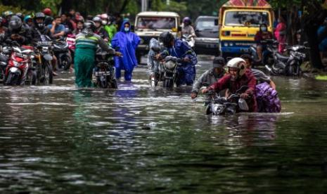 Warga mendorong sepeda motornya yang mogok dengan mengarungi jalan yang terendam banjir di Jalan Raya Arteri Soekarno-Hatta, Semarang, Jawa Tengah, Sabtu (6/2/2021). Sejumlah jalan protokol maupun alternatif di Kota Semarang terendam banjir dengan ketinggan bervariasi antara sekitar 20 sentimeter hingga sekitar 1 meter akibat curah hujan tinggi sejak Jumat (5/2) malam serta kurang lancarnya drainase yang menyebabkan lalu lintas terganggu. 