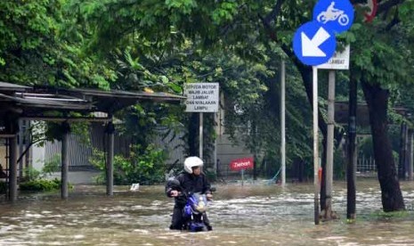 Warga menembus banjir di Cempaka Putih, Jakarta, Kamis (17/1). 