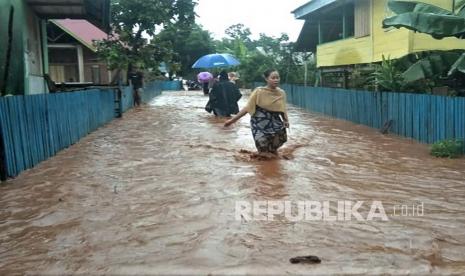 Warga menerobos banjir di Kecamatan Kabaena Selatan, Kabupaten Bombana, Sulawesi Tenggara, Senin (18/1/2021). Banjir mengakibatkan akses jalan tiga Desa Pongkalaero, Desa Puununu dan Desa Batuawu Kecamatan Kabaena Selatan terputus akibat luapan Sungai Kabaena. 