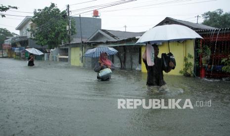 Warga menerobos banjir akibat air pasang dari laut (ilustrasi) 