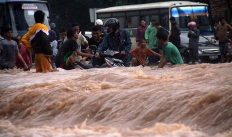 Warga menerobos banjir yang menggenangi kawasan jalan Sudirman, Jakarta, Kamis (17/1). 