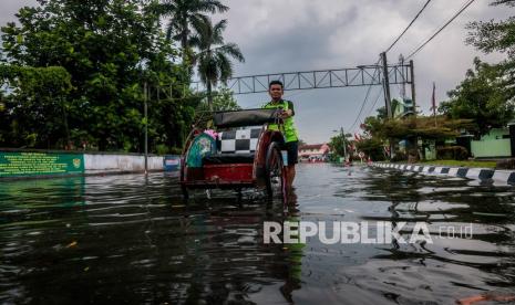 Warga menerobos genangan air di Rangkasbitung, Lebak, Banten, Selasa (7/9/2021). Tingginya curah hujan serta drainase yang buruk mengakibatkan genangan setinggi 30 cm hingga 60 cm merendam kawasan tersebut. 