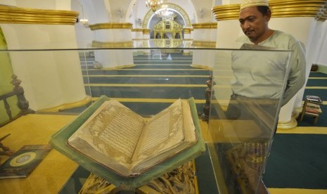 Warga mengamati Al-Quran yang dipajang di Masjid Raya Sultan Riau Pulau Penyengat, Kepulauan Riau, Rabu (24/2).