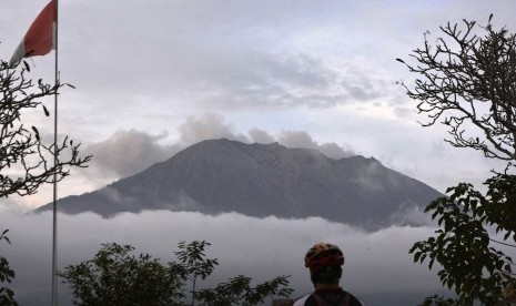 Warga mengamati asap yang mengepul dari kawah Gunung Agung di Pos Pemantauan Gunungapi Agung, Rendang, Karangasem, Bali, Selasa (3/7).