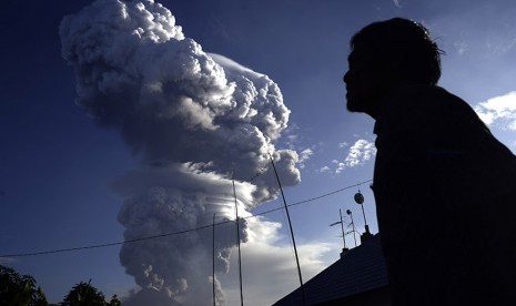 Warga mengamati awan panas yang mengepul dari puncak Gunung Soputan di Desa Silian 3, Minahasa Tenggara, Sulawesi Utara, Selasa (5/1).