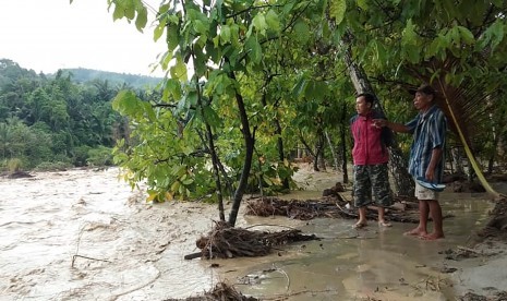 Warga mengamati banjir bandang yang melanda Desa Tuva, kecamatan Gumbasa, Kabupaten Sigi, Sulawesi Tengah, Senin (27/5/2019). 